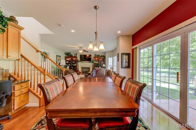 41 Deer Creek Dr, Ofallon, MO 63366 - dining area with light wood-style floors, ceiling fan, recessed lighting, a fireplace, and stairway