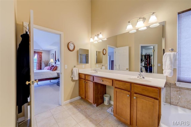 41 Deer Creek Dr, Ofallon, MO 63366 - ensuite bathroom featuring tile patterned flooring, double vanity, a towering ceiling, a bathtub, and baseboards