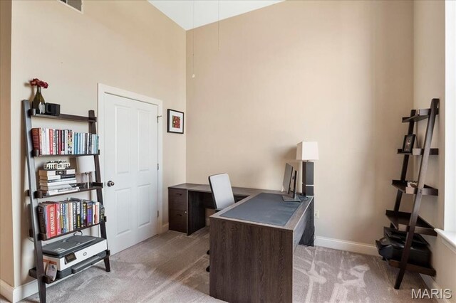 carpeted office featuring baseboards and a towering ceiling