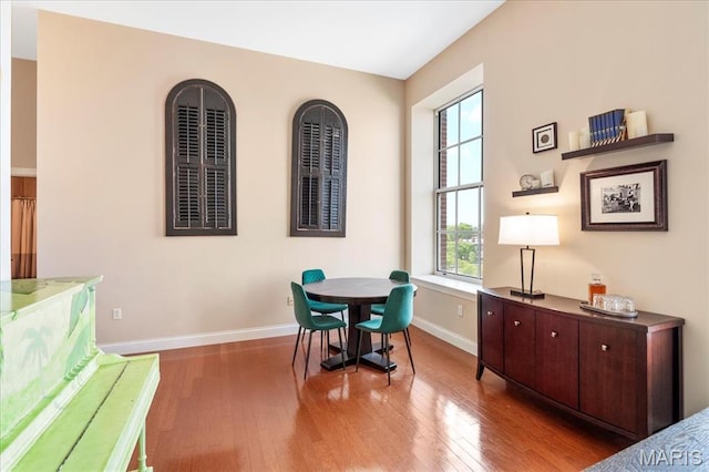 dining space with hardwood / wood-style floors and baseboards