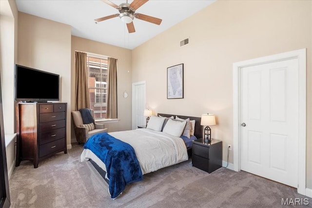 bedroom featuring light colored carpet, ceiling fan, and baseboards