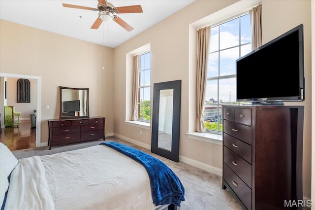 bedroom with baseboards, light carpet, and ceiling fan