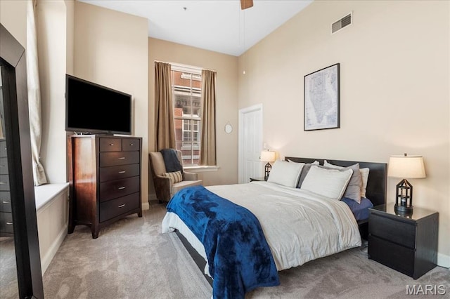 bedroom with light colored carpet, baseboards, and ceiling fan