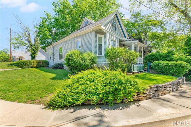 view of side of property featuring central AC and a yard