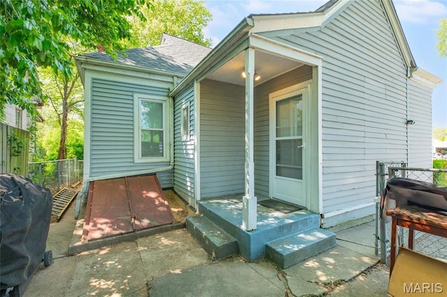 view of home's exterior featuring fence and a shingled roof
