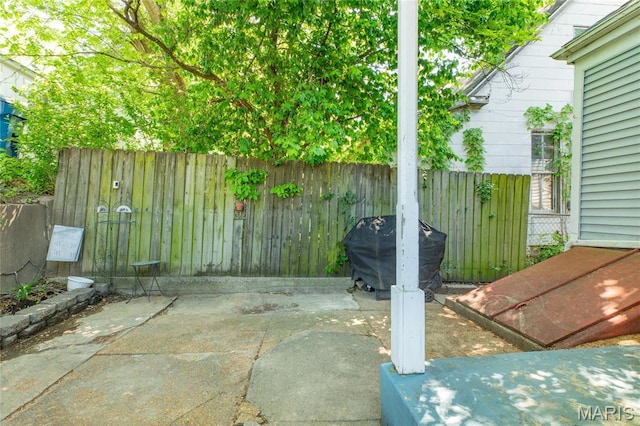 view of patio / terrace with fence and a grill