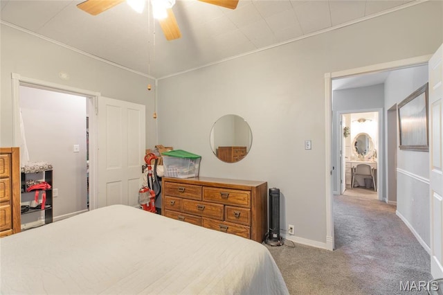 carpeted bedroom with ceiling fan, baseboards, and crown molding