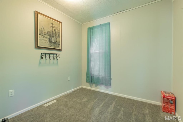 empty room featuring carpet floors, crown molding, a textured ceiling, and baseboards