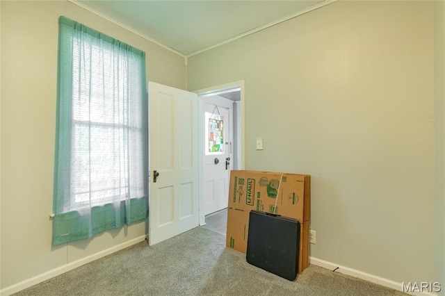 spare room featuring ornamental molding, carpet, and baseboards