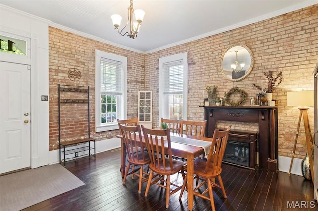 111 Portland Ave, Belleville, IL 62220 - dining space with a chandelier, plenty of natural light, hardwood / wood-style flooring, brick wall, and a glass covered fireplace