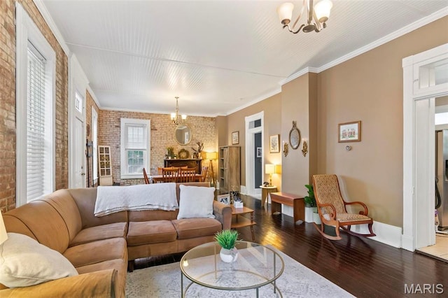 111 Portland Ave, Belleville, IL 62220 - living room featuring brick wall, a chandelier, wood-type flooring, baseboards, and crown molding