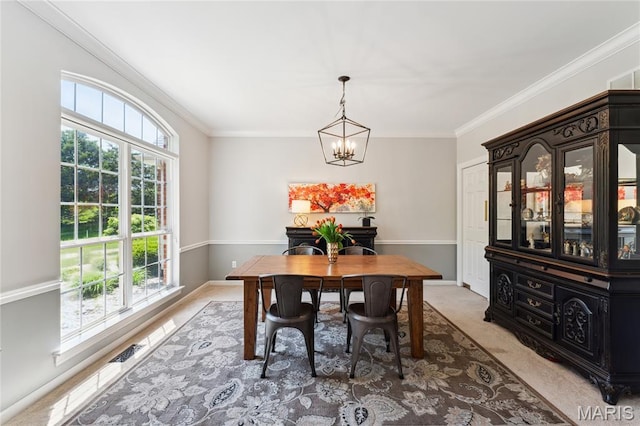 dining room with crown molding, a chandelier, light colored carpet, and baseboards