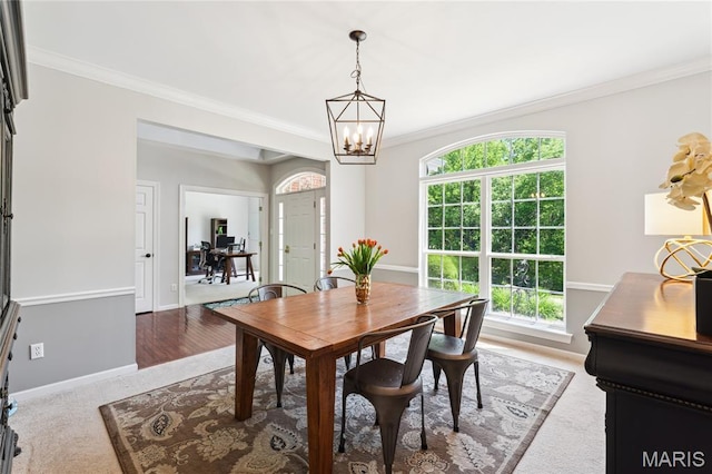 dining space featuring crown molding, healthy amount of natural light, a chandelier, and baseboards