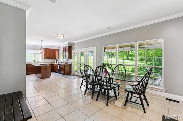 dining space featuring light tile patterned flooring, ornamental molding, and baseboards