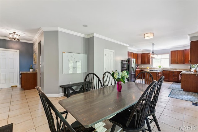 dining space with light tile patterned floors, crown molding, and baseboards