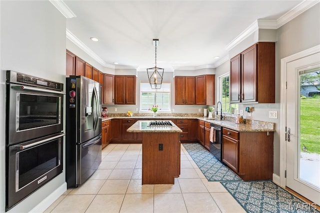 kitchen featuring stainless steel appliances, a kitchen island, a sink, ornamental molding, and light stone countertops