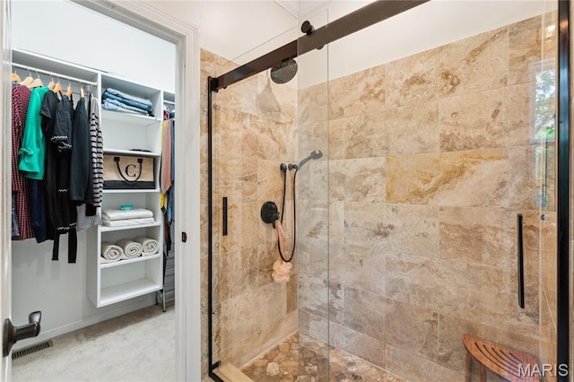 bathroom with a stall shower and a spacious closet