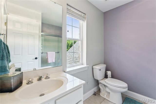 bathroom with baseboards, toilet, tile patterned flooring, a shower with shower door, and vanity