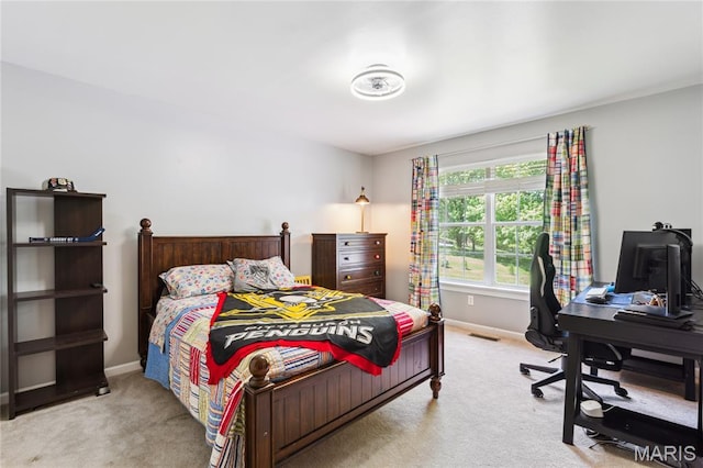 carpeted bedroom with baseboards and a desk