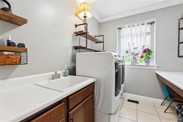 laundry area with ornamental molding, light tile patterned floors, cabinet space, baseboards, and washer and dryer