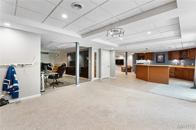 interior space featuring light carpet, bar with sink, baseboards, a paneled ceiling, and recessed lighting