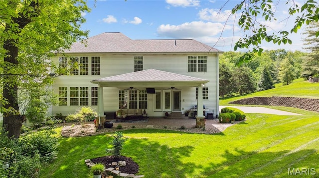 rear view of house with a ceiling fan, a yard, and a patio
