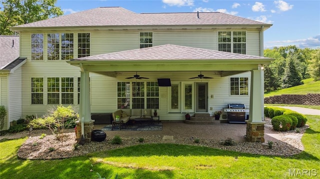 rear view of house with a ceiling fan, a patio area, and a lawn