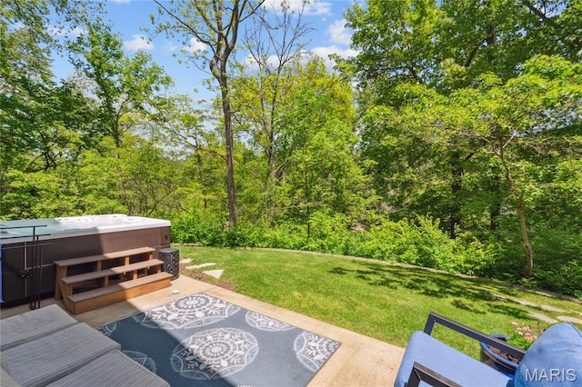 view of patio / terrace with a hot tub and a wooded view