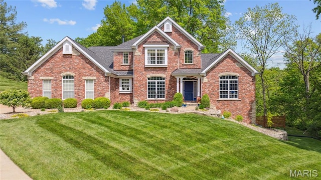 view of front of house featuring a front lawn and brick siding