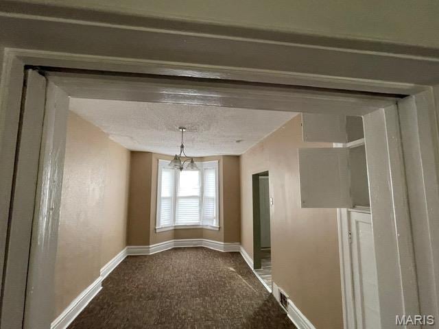 unfurnished dining area with baseboards, carpet floors, and a chandelier