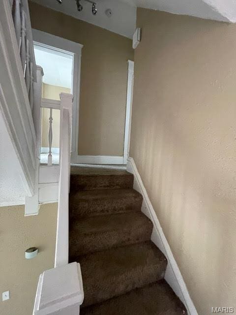 stairs with carpet floors and baseboards