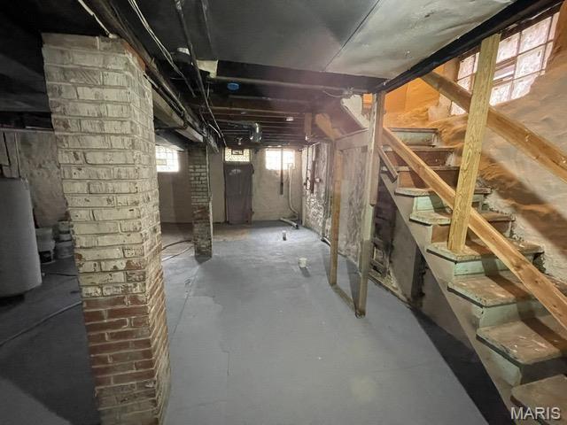 basement featuring water heater and stairs