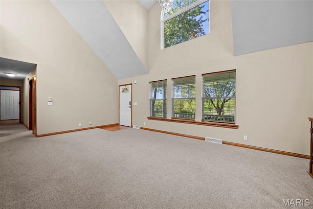 unfurnished living room featuring a high ceiling, carpet floors, and baseboards