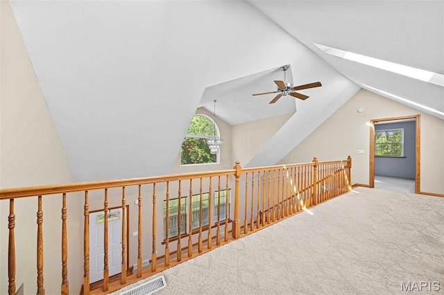 additional living space featuring lofted ceiling, healthy amount of natural light, a skylight, a ceiling fan, and carpet floors