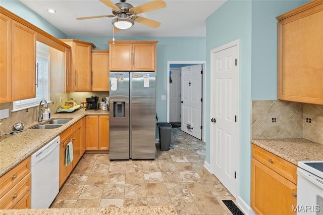 kitchen featuring stainless steel fridge with ice dispenser, dishwasher, a sink, decorative backsplash, and a ceiling fan