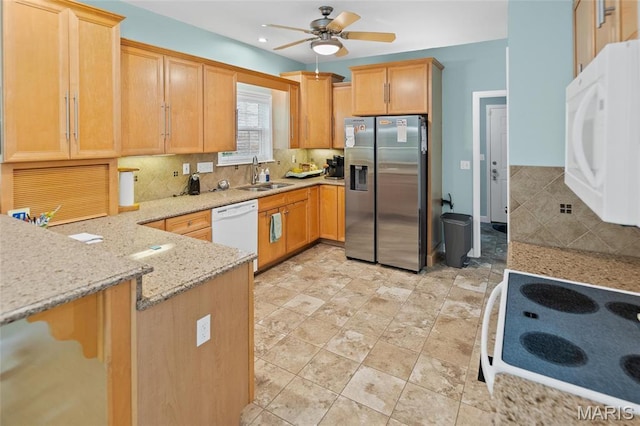 kitchen with white appliances, a sink, a ceiling fan, backsplash, and light stone counters