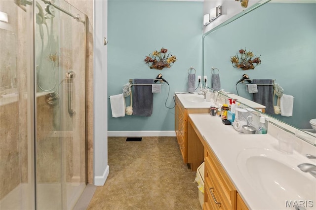 bathroom with a shower stall, vanity, and baseboards