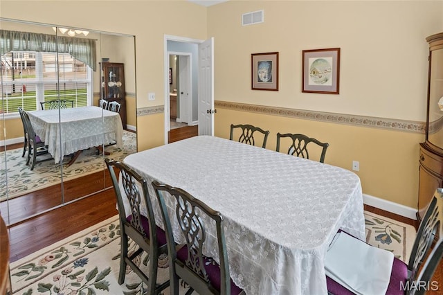 dining space with baseboards and wood finished floors