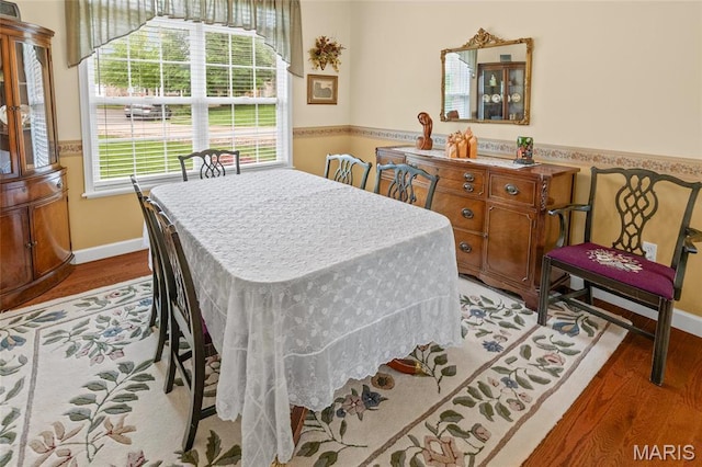 dining space featuring light wood finished floors and baseboards