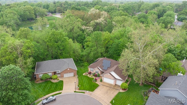 aerial view of property and surrounding area featuring a heavily wooded area