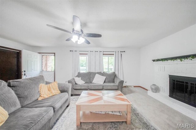 living area with healthy amount of natural light, ceiling fan, a fireplace, and baseboards