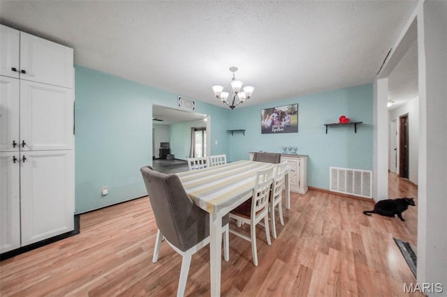 dining room with light wood-style flooring and a chandelier