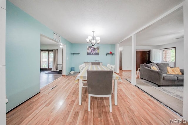 dining room featuring light wood-style flooring and a chandelier