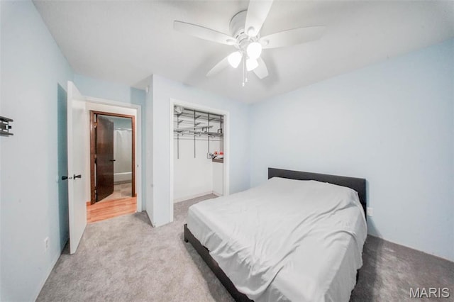 bedroom with light carpet, ceiling fan, and a closet