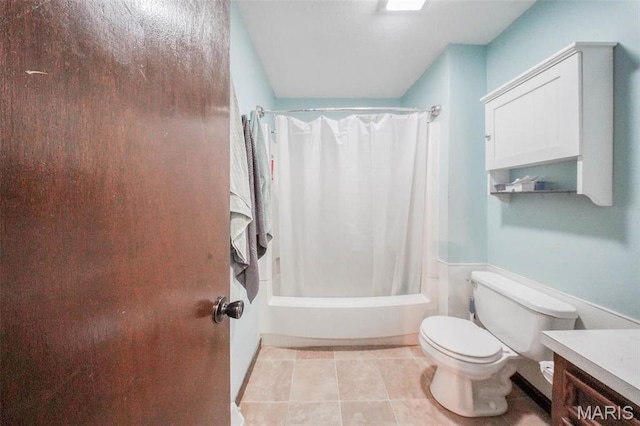 bathroom with toilet, tile patterned flooring, shower / bath combo with shower curtain, and vanity