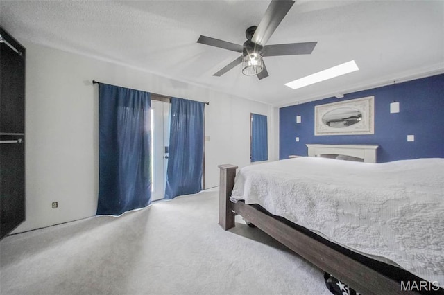 bedroom featuring a skylight, carpet flooring, and ceiling fan