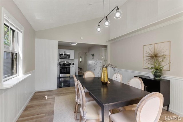 312 Waller Ave, Saint Louis, MO 63125 - dining space with light wood finished floors, vaulted ceiling, a wainscoted wall, and arched walkways