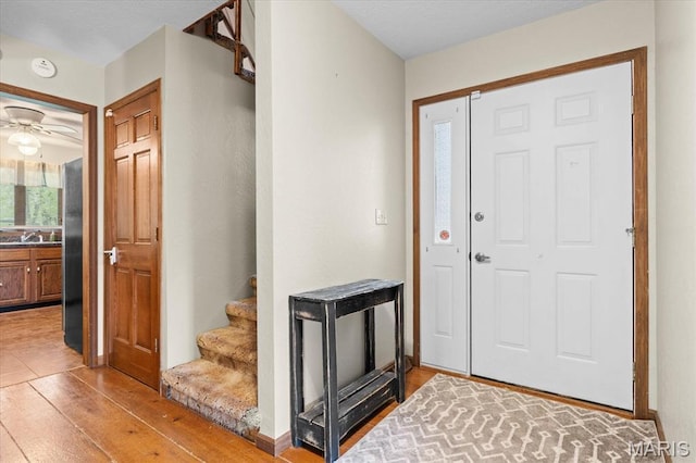 22000 E Rd, Carlyle, IL 62231 - entryway with light wood-type flooring, a ceiling fan, and stairs