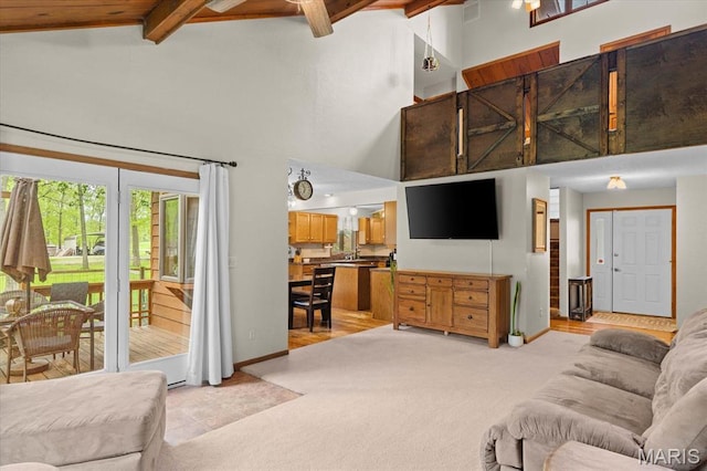 22000 E Rd, Carlyle, IL 62231 - living area with beam ceiling, light colored carpet, high vaulted ceiling, ceiling fan, and baseboards