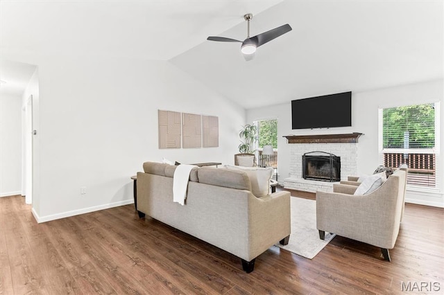 living area featuring healthy amount of natural light, wood finished floors, a brick fireplace, and lofted ceiling